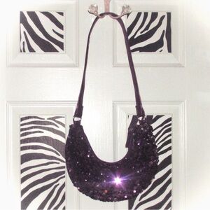Purple and gold sequin shoulder bag with a zipper closure.